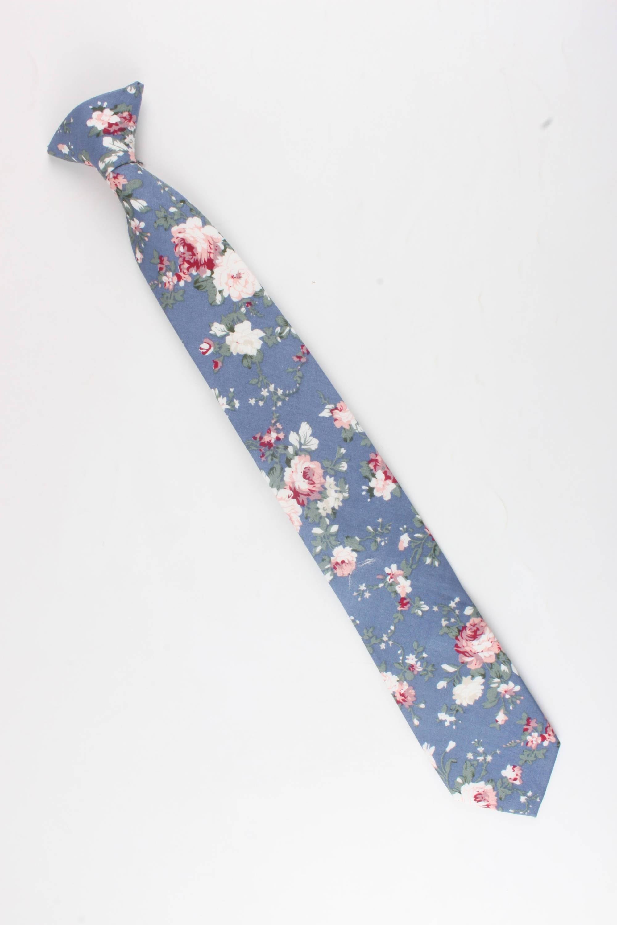 Boys Floral Clip On Tie 2.3&quot; NEIL-Boys Floral Clip On Tie Material:Cotton Blend Approx Size: Max width: 6.5 cm / 2.4 inches 9-24 months 26 CM2-5 years 31 CM9-11 Years 43 CM Get your little man looking sharp with this blue floral print tie. This dapper clip-on tie is perfect for any formal occasion, from weddings to christenings. The blue floral print is just the right amount of dainty, and the fit is tailored to fit boys of all ages. With a versatile style that can be dressed up or down, this ti