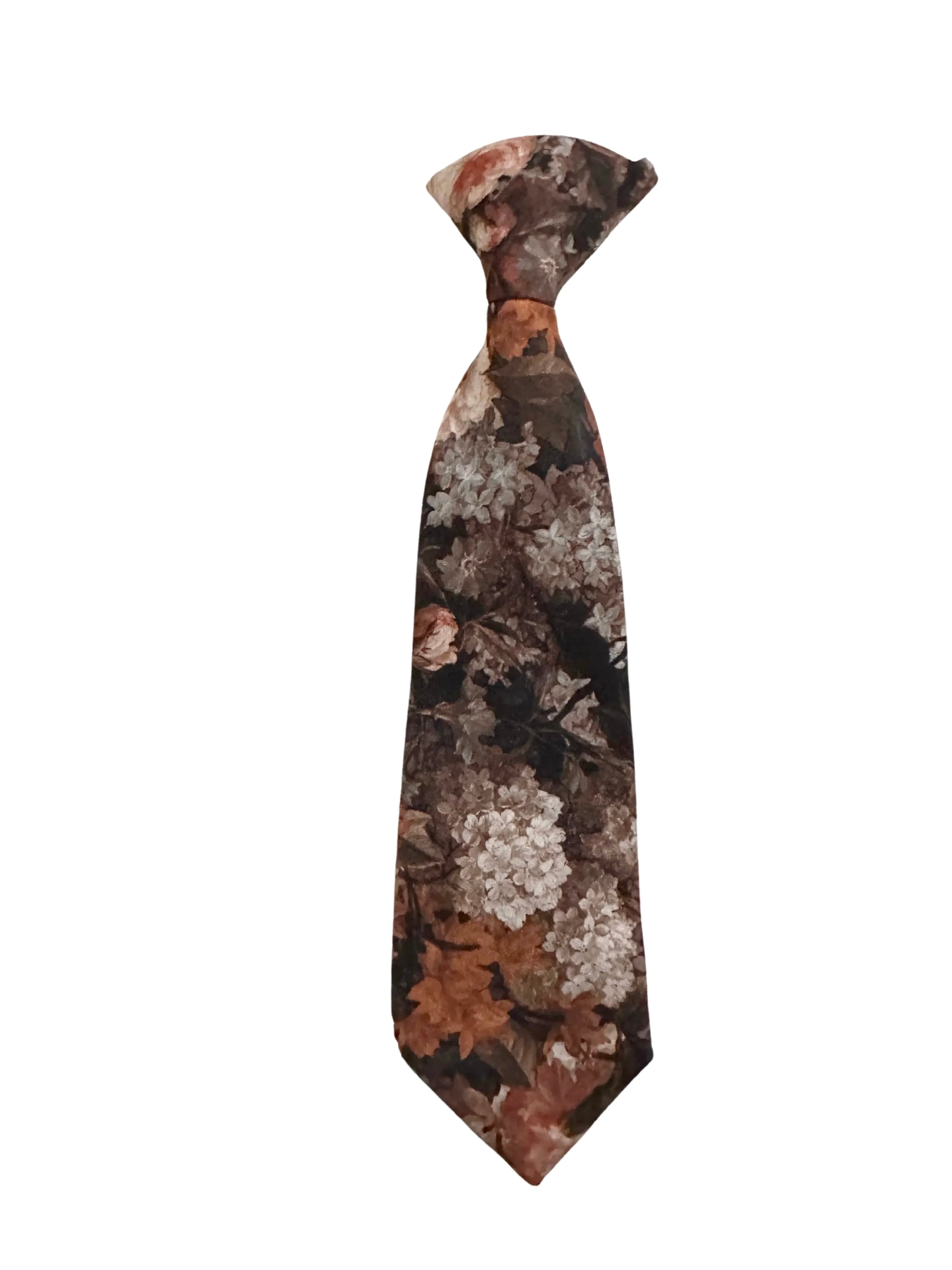 Spruce up your little one's wardrobe with this Boys Floral Clip On Tie. This boys tie is perfect for adding a touch of dapper to any outfit. Whether it's for a wedding, a family gathering, or a day at the office, this tie is sure to make your little one stand out from the rest. The clip-on design makes it easy to put on and take off, even for the littlest of gentlemen. And the floral pattern is sure to add a touch of personality to any outfit.  Theophilus floral tie mytieshop